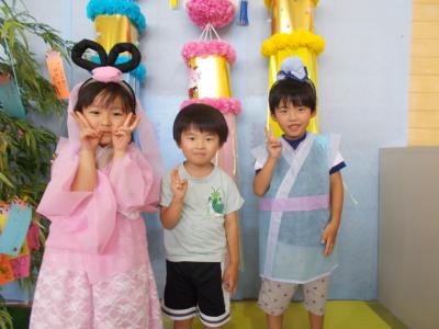七夕飾りでピースする男の子ふたりと女の子