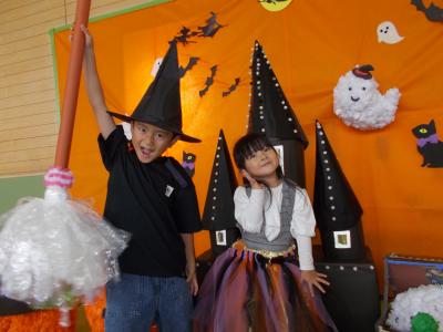 ハロウィンの飾りの中でポーズするきょうだい