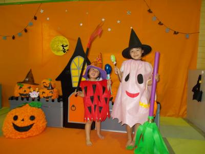 ハロウィンの飾りの中でポーズする二人のきょうだい