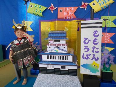 子どもの日のセットの中で男の子がピース