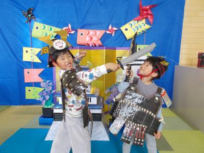 子どもの日のセットの中で戦いごっこ